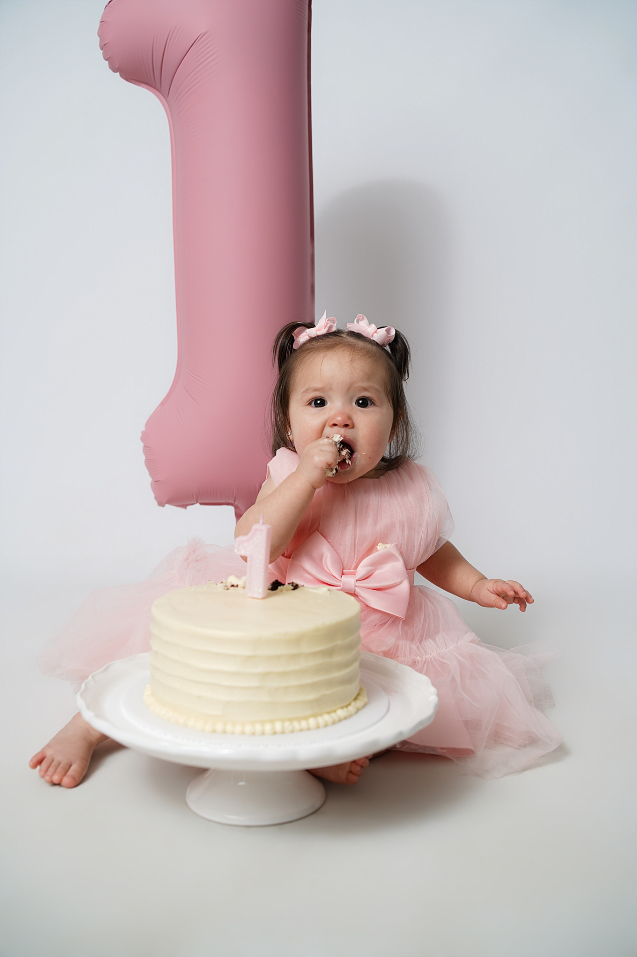 Cake smash moment with pink number one balloon