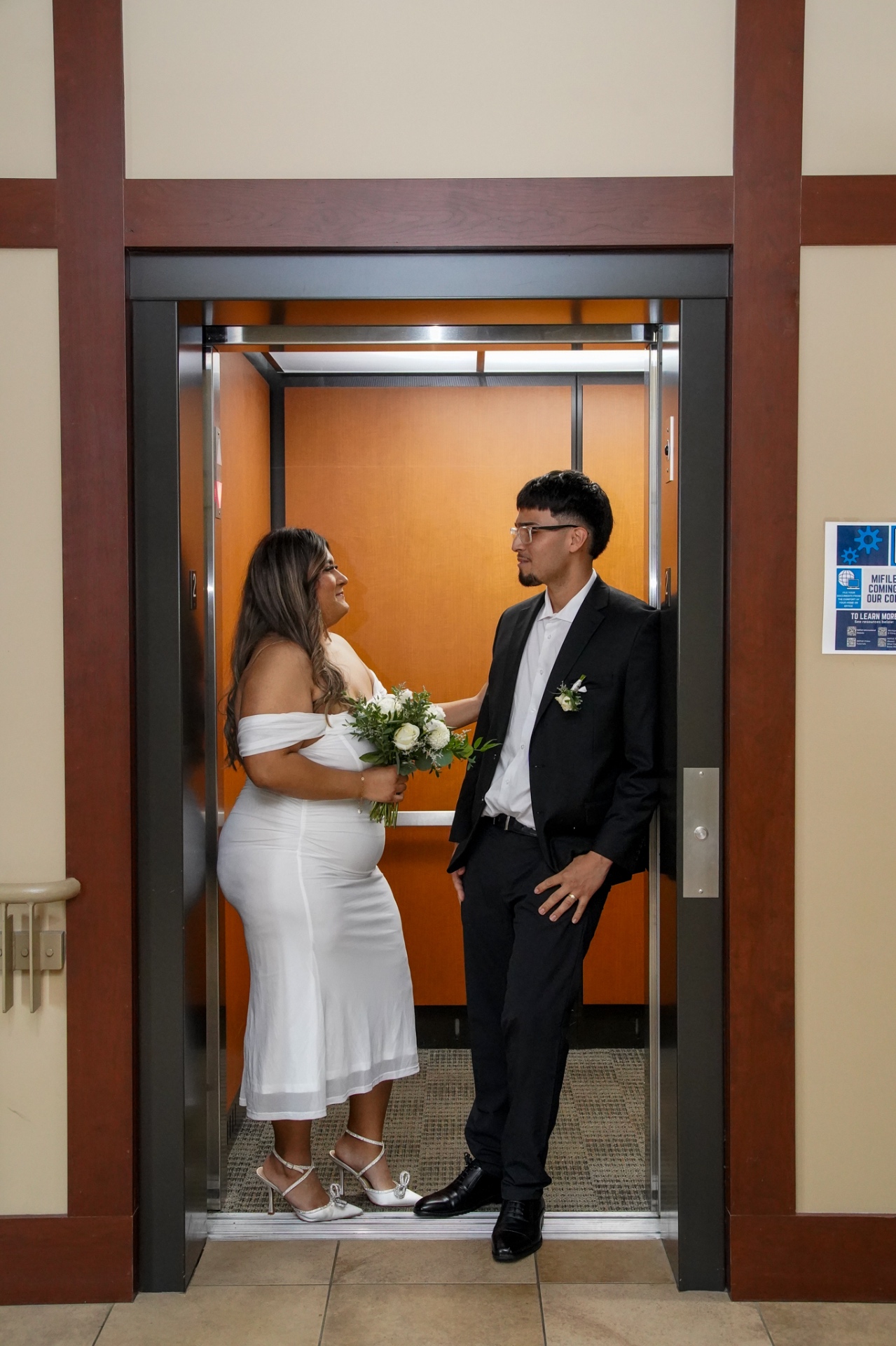 Bride and groom sharing a quiet moment in the courthouse elevator