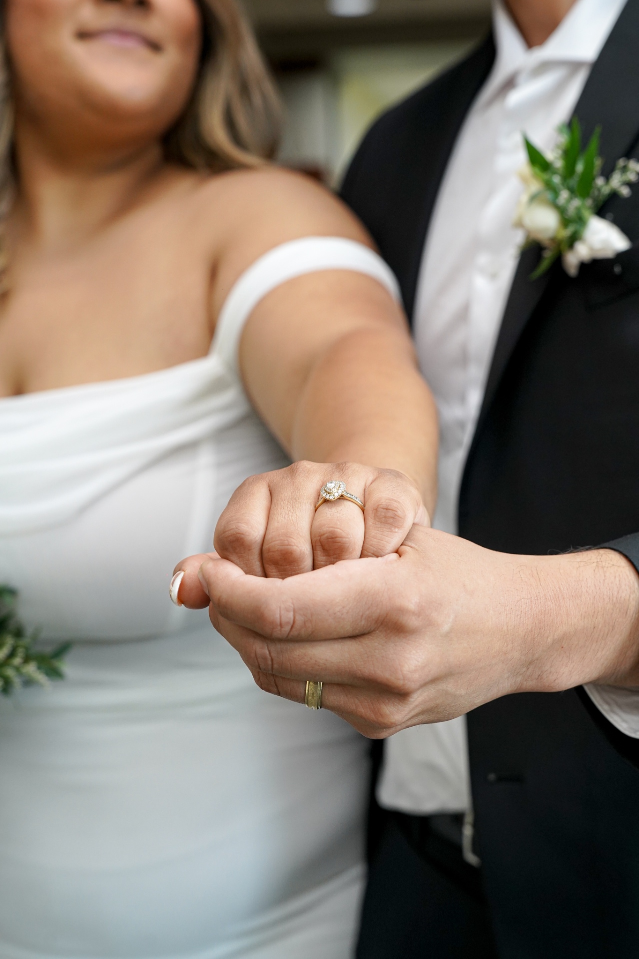 Close-up of the bride's engagement ring as the couple holds hands