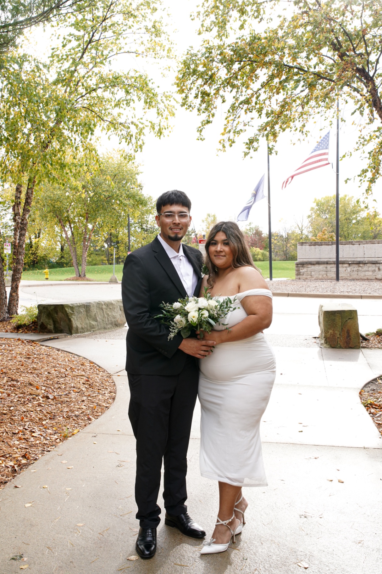 Bride and groom portrait outside the courthouse with autumn trees